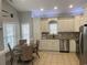 Well-lit kitchen with white cabinets, stainless steel appliances, and a cozy dining area at 6001-O4 S Kings Hwy., Myrtle Beach, SC 29575