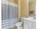 Well-lit bathroom with a toilet, sink, mirror, and a shower featuring a gray and white striped shower curtain at 6203 Catalina Dr. # 1822, North Myrtle Beach, SC 29582