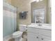 Cozy bathroom with floral wallpaper, a toilet, a sink, and a shower featuring a striped shower curtain at 6203 Catalina Dr. # 1822, North Myrtle Beach, SC 29582