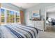 Bright bedroom features a large window, blue striped bedding, and an entertainment center with a beach scene on TV at 6203 Catalina Dr. # 1822, North Myrtle Beach, SC 29582
