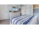 Bright bedroom with a queen bed, white furniture, and an entertainment center, connected to a bathroom and dining area at 6203 Catalina Dr. # 1822, North Myrtle Beach, SC 29582