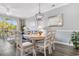 Charming dining area with a round table, six chairs, modern chandelier, and views of the outdoor patio at 6203 Catalina Dr. # 1822, North Myrtle Beach, SC 29582