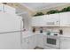 Kitchen featuring white cabinets, white appliances, and an arched opening at 6203 Catalina Dr. # 1822, North Myrtle Beach, SC 29582