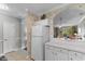 Well-lit kitchen featuring white appliances and cabinets, complemented by tropical-themed wallpaper and an open counter at 6203 Catalina Dr. # 1822, North Myrtle Beach, SC 29582