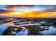 Aerial view of a coastal town's waterfront with marshland, buildings, and a vibrant sunset at 624 Blackberry Ave., Murrells Inlet, SC 29576