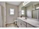 Well-lit bathroom featuring a large mirror, white cabinets, and ample natural light at 624 Blackberry Ave., Murrells Inlet, SC 29576