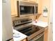 Stainless steel microwave and range above the stove with white countertops and light wood cabinets at 649 Tupelo Ln. # 13E, Longs, SC 29568