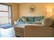Comfortable living room with a blue sofa, armchair, tile floor, and view to balcony at 649 Tupelo Ln. # 13E, Longs, SC 29568