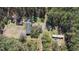 A bird's eye aerial view shows a residence and outbuildings surrounded by forest at 77 Towhee St., Georgetown, SC 29440