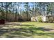 A property with a mobile home, storage building and mature trees at 77 Towhee St., Georgetown, SC 29440