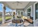 Inviting screened porch featuring comfortable wicker furniture, a ceiling fan, and serene outdoor views at 804 Yauhannah Dr., Little River, SC 29566