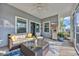 This screened porch is perfect for relaxing with a cozy couch, stylish decor, and views of the backyard at 804 Yauhannah Dr., Little River, SC 29566