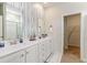 Bathroom with double sinks, stylish blue wallpaper, and a view to the walk-in closet at 8081 Bear Claw Way, Conway, SC 29526