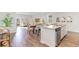 Open-concept kitchen with island, granite countertops, stainless appliances and wood floors blending cooking and living spaces at 8081 Bear Claw Way, Conway, SC 29526