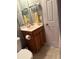 Bathroom vanity with wooden cabinets and a white door nearby at 1001 Leatherman Rd., Conway, SC 29527