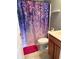 Bathroom with a floral shower curtain, wood cabinets, and tile flooring at 1001 Leatherman Rd., Conway, SC 29527