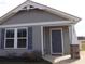 Close up of a charming single story home with gray siding, blue shutters, and an inviting front entrance at 1001 Leatherman Rd., Conway, SC 29527