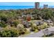 A scenic aerial view of a house situated near the ocean, surrounded by lush greenery and neighborhood homes at 5616 N Kings Hwy., Myrtle Beach, SC 29577