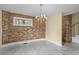 Empty dining room featuring a decorative chandelier, brick accent wall and neutral paint at 5616 N Kings Hwy., Myrtle Beach, SC 29577