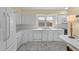 Bright kitchen featuring white cabinetry, tiled backsplash, and a window overlooking the outdoor space at 5616 N Kings Hwy., Myrtle Beach, SC 29577