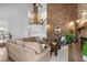 Spacious living room with a brick fireplace, plush seating, and a striking brick accent wall at 5616 N Kings Hwy., Myrtle Beach, SC 29577