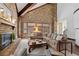 Cozy living room with a brick fireplace, vaulted ceilings with wooden beams, and lots of light at 5616 N Kings Hwy., Myrtle Beach, SC 29577