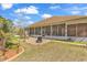 Spacious backyard with patio area, brick facade, green grass, and lush landscaping at 129 Waterfall Circle, Little River, SC 29566