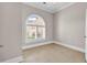 Bedroom with tiled floor, arched window, plantation shutters, and neutral paint at 129 Waterfall Circle, Little River, SC 29566