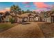 Charming brick home with a well-manicured lawn, large driveway and mature landscaping at sunset at 129 Waterfall Circle, Little River, SC 29566