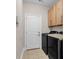 Functional laundry area featuring wooden cabinetry and black front load washing machines at 129 Waterfall Circle, Little River, SC 29566