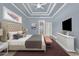 Well-lit main bedroom featuring tray ceiling, with an ensuite bathroom nearby at 129 Waterfall Circle, Little River, SC 29566