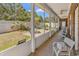 Enclosed patio with backyard view, white furniture, and access to the yard at 129 Waterfall Circle, Little River, SC 29566