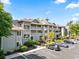 This is an eye-level view of a condo building showcasing its well-kept landscape, ample parking, and inviting exterior design at 1551 Spinnaker Dr. # 5821, North Myrtle Beach, SC 29582