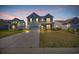 Exterior front elevation of a two-story home with a well-lit lawn at dusk at 3304 Candytuft Dr., Conway, SC 29526