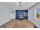Bright living room features a blue accent wall, stylish decor, and hardwood floors at 3304 Candytuft Dr., Conway, SC 29526