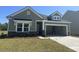 Charming single-Gathering home featuring green siding, stone accents, and an attached two-car garage at 3317 Sw Wood Stork Dr., Ocean Isle Beach, NC 28469