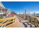 The wooden boardwalk offers waterfront access with views of boats, restaurants, and the clear blue sky at 4305 Lotus Ct. # G, Murrells Inlet, SC 29576
