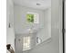 White staircase showcasing multiple windows for natural light, with a stylish light fixture at 4305 Lotus Ct. # G, Murrells Inlet, SC 29576