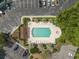 Aerial view of outdoor swimming pool and parking lot surrounded by mature green trees and well kept landscaping at 4616 Greenbriar Dr. # H8, Little River, SC 29566