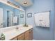 A well-lit bathroom features a vanity, large mirror, and nautical themed décor at 4616 Greenbriar Dr. # H8, Little River, SC 29566