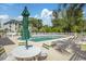 Outdoor swimming pool with lounge chairs and umbrellas surrounded by mature green trees and greenery at 4616 Greenbriar Dr. # H8, Little River, SC 29566