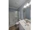 Well-lit bathroom featuring a shower with glass doors, vanity with stone countertop, and wood look floors at 605 15Th Ave. S, North Myrtle Beach, SC 29582