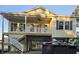 Stunning elevated beach home featuring a front porch, blue shutters, and classic coastal design at 605 15Th Ave. S, North Myrtle Beach, SC 29582