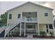 Inviting two-story raised home with a covered porch, staircase, and fenced-in backyard at 605 15Th Ave. S, North Myrtle Beach, SC 29582