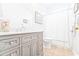 Bathroom featuring a gray vanity with marble countertop, adjacent to a toilet and shower with white tile at 728 Camden Circle, Pawleys Island, SC 29585
