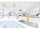 Bright, open kitchen features quartz counters, tiled backsplash, and stainless steel sink with designer fixtures at 728 Camden Circle, Pawleys Island, SC 29585