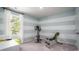 This workout room features exercise equipment, blue and white striped walls, and a window for natural light at 382 Ladyfish Loop, Sunset Beach, NC 28468