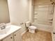 Bright bathroom features a shower-tub combo, toilet and sink with cabinet with tan tiling at 5088 Wavering Place Loop, Myrtle Beach, SC 29579