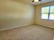 Empty bedroom with a light-colored carpet, a ceiling fan and a window letting in lots of natural light at 5088 Wavering Place Loop, Myrtle Beach, SC 29579