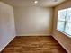 Empty bedroom with hardwood floors and bright natural light from the window at 5088 Wavering Place Loop, Myrtle Beach, SC 29579